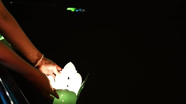 Hands Releasing Lanterns in Hoi An, Vietnam