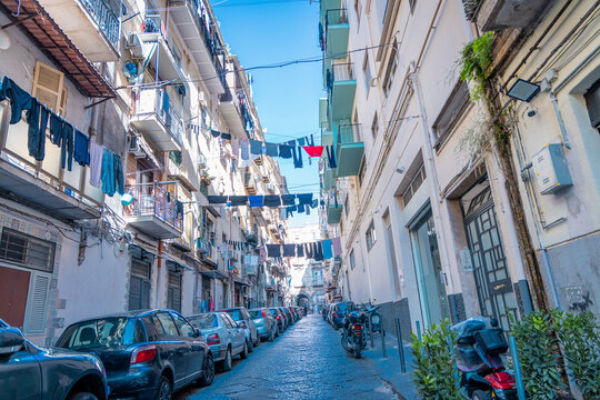 Fototapeta Typical streets in Napoli downtown or old city. Narrow streets with high buildings, clothes hanging on lines and drying bwtween the buildings. Moto scooters everywhere