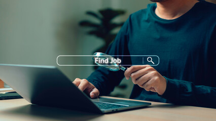 A person using a laptop while holding a magnifying glass, symbolizing online job search and digital recruitment concepts in a modern workplace setting. explore career opportunities in a competitive.