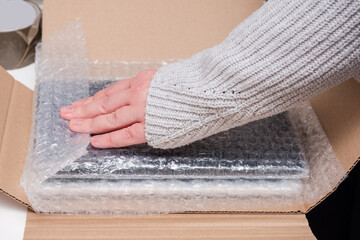 Person is wrapping a package with bubble wrap