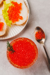 Red caviar in a caviar dish with a sprig of dill