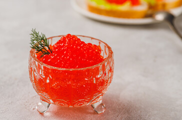 Red caviar in a caviar dish with a sprig of dill