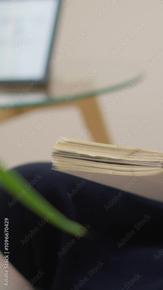 Poster a woman is sitting at a home office desk, writing in a notepad with a laptop in the background. she 