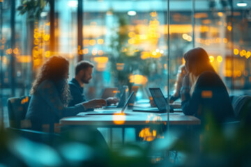 Blurred background of a group of people are sitting at a table in a restaurant, working on their laptops. The atmosphere is casual and relaxed