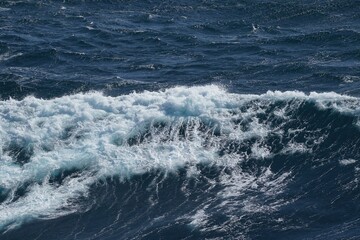 Ocean waves crashing with white foam, creating dynamic seascape. deep blue water contrasts beautifully with frothy surf, evoking sense of tranquility and power