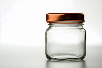 Clear glass jar with a copper lid, isolated on a white background, ideal for storage or decorative use