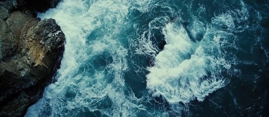 Aerial view of ocean waves crashing against rocky coastline highlighting natural beauty and turbulent marine environment