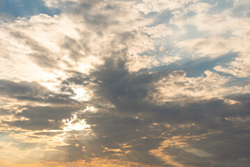 Fototapeta premium Clouds illuminate the sky with rays of sunlight during a serene sunset over a tranquil horizon