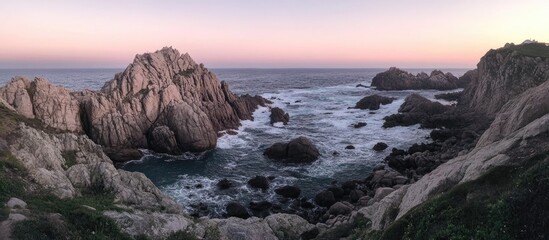 Serene rocky coastline at dusk with gentle waves and soft pastel sky in the background.