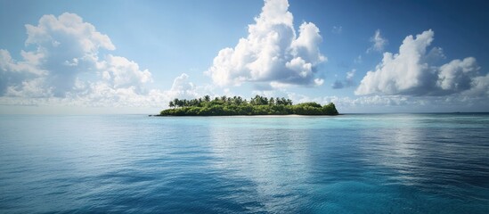 Serene aerial view of a tropical island surrounded by calm waters and fluffy clouds under a bright blue sky