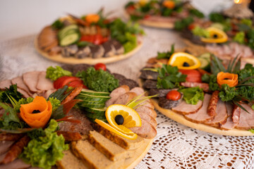 A traditional meat platter with sausages, cold cuts, and garnishes like lettuce, orange slices, and vegetables, beautifully arranged on a table. Perfect for events, celebrations, and festive gathering