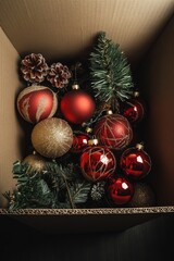 Box filled with Christmas ornaments and pine cones