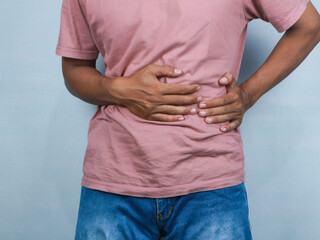 Young man suffering from an abdominal pain, healthcare concept white background