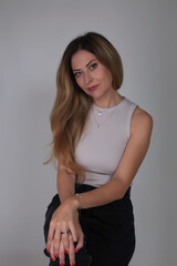 Portrait of a beautiful fashion girl blond in the studio in a nice black trousers