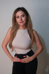 Portrait of a beautiful fashion girl blond in the studio in a nice black trousers