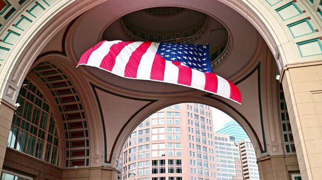 A huge American flag flying from a high ceiling in Boston, Massachusetts, USA on a cloudy morning.