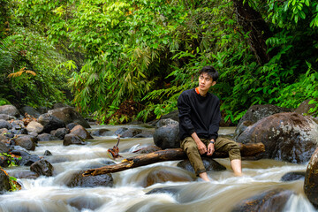 Man sitting on the river while looking around.