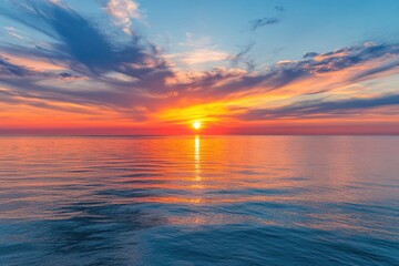 Fototapeta premium A serene scene with the sun dipping below the ocean's surface, creating a warm glow