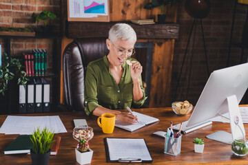 Photo of successful lady boss dressed shirt eyewear eat snack write task workplace workstation loft...