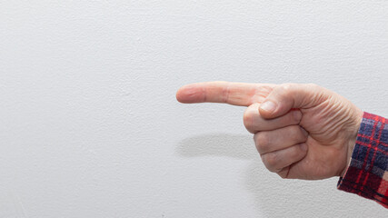 male hand wearing a checkered shirt points to the right, offering a clear directional cue against a...
