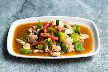 Chicken with Green Chili, Onion, Capsicum and Red Chilli curry served in tray dish isolated on grey background side view of thai food