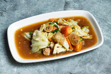 Mixed Stir fry Vegetables including cabbage, cauliflower, mushroom, carrot, tomato and green chilli served in tray dish isolated on grey background side view of thai food