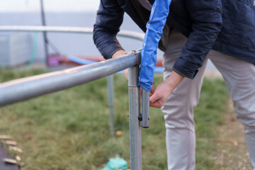 Disassembling and assembling the trampoline. The disassembled trampoline frame is prepared for storage.