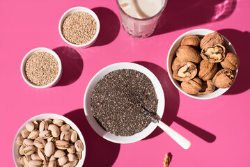 Semillas de chía, sésamo, nueces y pistachos. Frutos secos sobre un fondo rosa. Vista superior