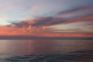Obraz premium Red clouds at sunset over the sea