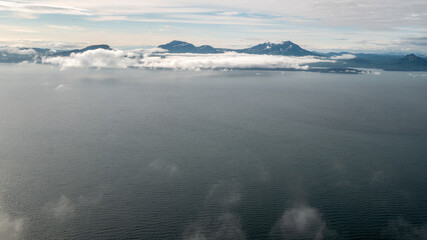 Ocean in Alaska with distant mountains and clouds