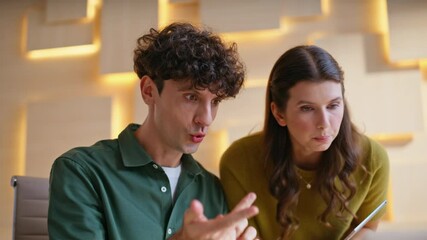 Two employees discussing virtual meeting looking laptop at workplace closeup.