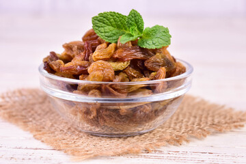 Raisins in a glass bowl on a white background.Close-up.
