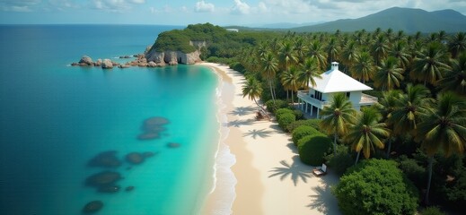 Fototapeta premium Aerial view of a lush tropical beach with a white house, palm trees, and clear turquoise waters. 