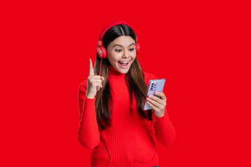 Millennial girl choose song in playlist. Teen girl isolated on red. Listening music headphones....