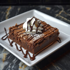 A single brownie served on a white plate with a dollop of whipped cream and chocolate drizzle