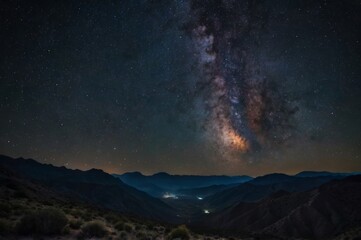 night sky filled with stars, including the Milky Way, over a dark silhouette of mountains