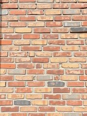 Obraz premium Weathered and rustic brick wall with various shades of red, brown, and beige bricks, building