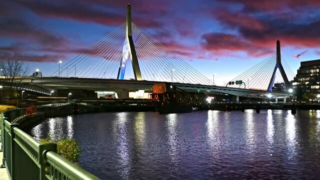 The historic architecture of Boston in Massachusetts, USA showcasing the iconic Zakim bridge by the TD Garden at sunrise spanning over the Charles river.