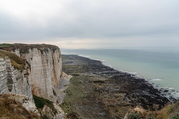 Scenic view of the white chalk cliffs and rocky coastline of Etretat, France