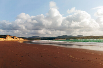 A beach with a cloudy sky in the background