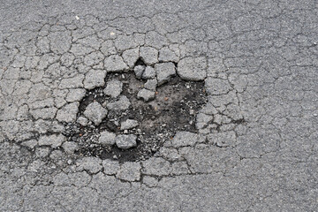 large hole on asphalt road, highway with dirt mud pothole and fracture, damage textured tarmac...