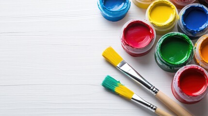 Acrylic paint tubes, painting knives, and a blank canvas arranged on a clean white background