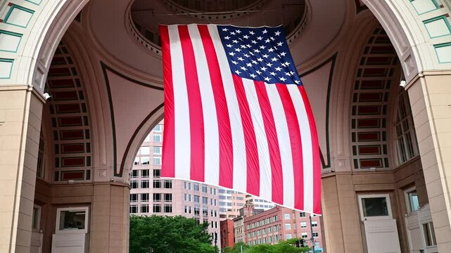 A huge American flag swinging in the wind in Boston, Massachusetts, USA at Government Center.