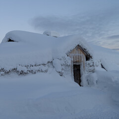 Christmas time with a house in the mountains covered with a thick layer of snow