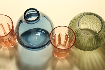 Empty glass vases on beige background, above view