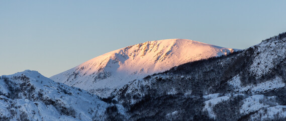 the sun shines on the mountain peaks