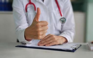 Doctor shows OK or approval sign with thumbs up
