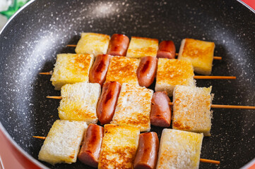 フライパンで焼くパンとウインナー