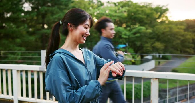 Exercise, bridge and woman with watch, fitness and tracking of progress, healthy and morning for routine. Outdoor, wellness and Japanese person with timer for workout, active and app for runner