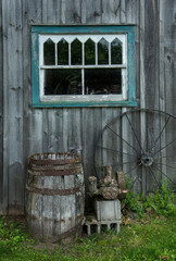 old pump barrel and wheel outside old building